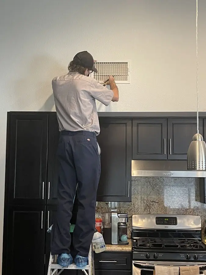 Technician inspecting an air vent during HVAC service in Murrells Inlet